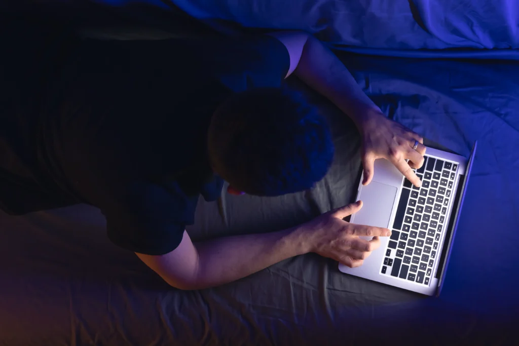 Businessman and freelancer working late at night on a laptop, showing the impact of weak digital boundaries on sleep